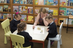 PRIMARY STUDENTS READING IN LIBRARY